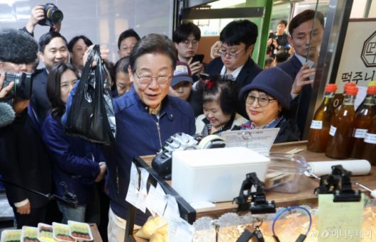 (인제=뉴스1) 이재명 기자 = '골목골목 경청투어 : 접경벨트편'에 나선 이재명 더불어민주당 대통령 후보가 2일 오후 강원 인제군 북면 원통시장에 위치한 떡집을 찾아 지역화폐로 콩가루를 구입하고 있다. (공동취재) 2025.5.2/뉴스1  Copyright (C) 뉴스1. All rights reserved. 무단 전재 및 재배포,  AI학습 이용 금지. /사진=(인제=뉴스1) 이재명 기자