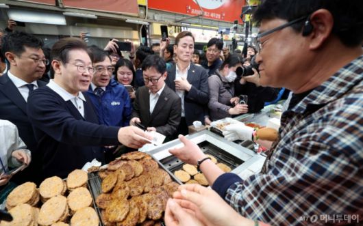 [단양=뉴시스] 조성봉 기자 = 민심을 청취하는 '경청 투어'에 나선 이재명 더불어민주당 대선후보가 4일 충북 단양구경시장에서 떡갈비를 구매하고 있다. 있다.2025.05.04. suncho21@newsis.com /사진=조성봉