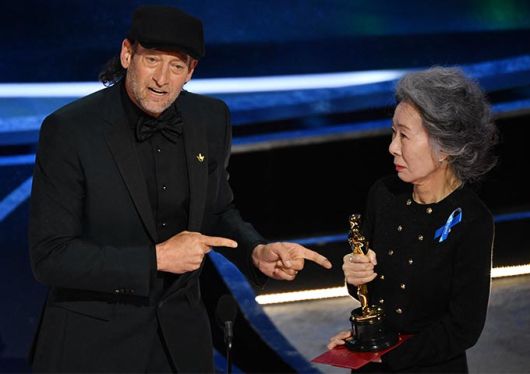 시상자로 나선 배우 윤여정(오른쪽)이 영화 '코다'로 남우조연상을 수상한 배우 트로이 코처(왼쪽)가 수어로 수상 소감을 밝힐 수 있도록 트로피를 들어주는 모습./사진=AFP/뉴스1