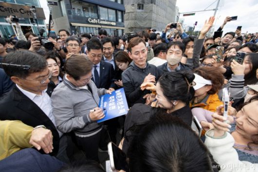 (강릉=뉴스1) 이재명 기자 = '골목골목 경청투어 : 동해안벨트편'에 나선 이재명 더불어민주당 대통령 후보가 3일 오후 강원 강릉시 안목해변에서 한 지지자 요청에 손팻말에 서명하고 있다. 2025.5.3/뉴스1  Copyright (C) 뉴스1. All rights reserved. 무단 전재 및 재배포,  AI학습 이용 금지. /사진=(강릉=뉴스1) 이재명 기자