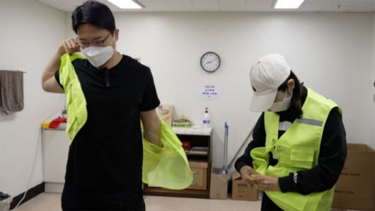 재활용 선별 수작업을 하기 위해 준비하고 있는 기자(왼쪽)와 정주희 기후캐스터(오른쪽)./사진=서울시, 이상열 미디어트립 PD