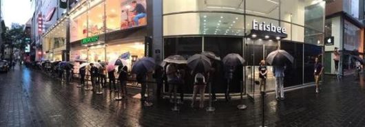 명동 프리스비 매장 앞에 애플워치를 구입하기 위해 줄선 소비자. 프리스비 건물 옆에는 금강제화의 랜드로바가 있다. 이 건물은 김성환 금강 회장이 소유하고 있다.