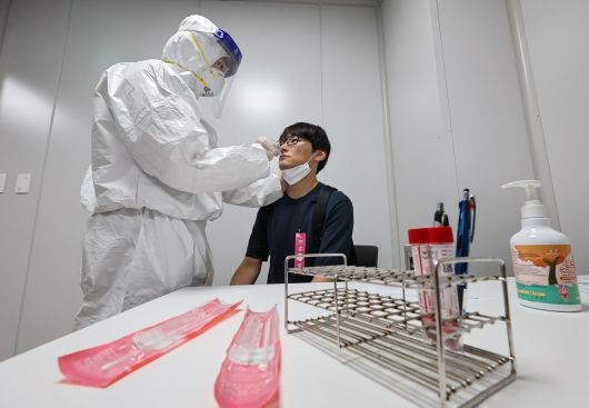 지난 3일 인천국제공항 제2여객터미널에서 열린 ‘수도권 해외유입 신종감염병 대응 합동훈련'에서 임상증상 자진신고 승객을 가정한 훈련 참가자가 검체 채취를 하고 있다./뉴스1