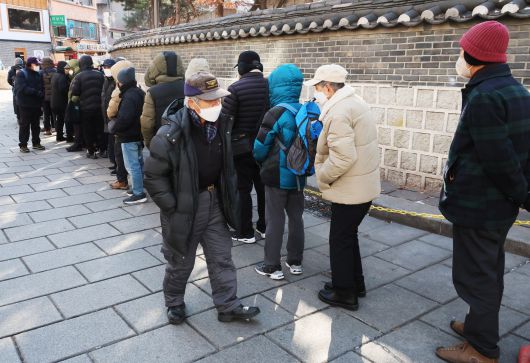 서울 종로구 탑골공원 원각사 노인무료급식소 앞에 어르신들이 점심식사를 위해 줄지어 서 있다. /연합뉴스