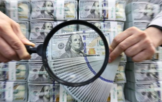 서울 중구 하나은행 위변조대응센터에서 직원이 달러 지폐를 살펴보고 있다. / 뉴스1