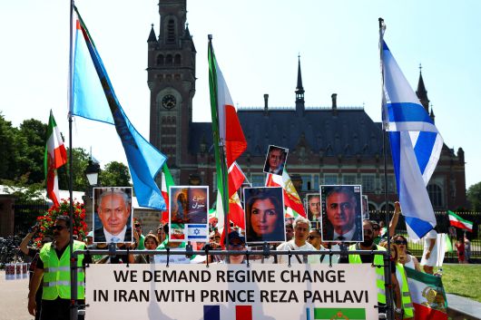 시위대가 21일 네덜란드 헤이그에서 열리는 NATO 정상회담을 앞두고 이란 정권에 항의하는 시위를 벌이는 동안 이스라엘 총리 베냐민 네타냐후, 망명 중인 이란 레자 팔라비 왕자, 야스민 팔라비 사진을 흔들고 있다. /연합뉴스