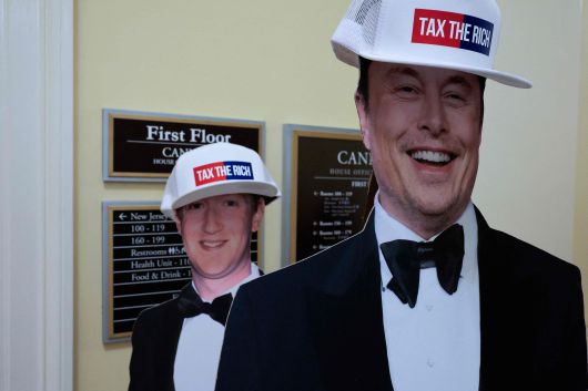 지난 5월 13일(현지시각) 미국 민주당 의원들이 공화당의 메디케이드(저소득층 건강보험) 삭감 계획에 반대하는 기자회견을 열고 있는 가운데, 일론 머스크와 마크 저커버그의 등신대가 캐넌 하우스 오피스 빌딩 복도에 세워져 있다./연합뉴스