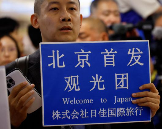 일본 도쿄 하네다공항에서 한 여행사 직원이 베이징에서 출발하는 중국인 여행단 도착을 기다리고 있다. /연합뉴스