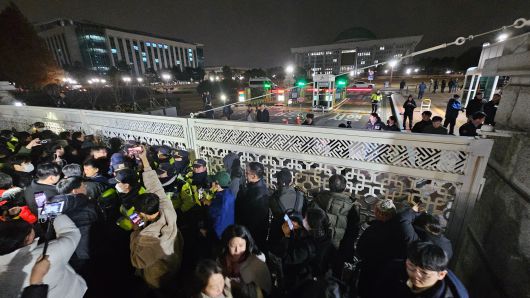 2024년 12월 3일 밤 비상계엄령이 선포된 가운데 서울 여의도 국회가 봉쇄된 채 국회 정문 앞에서 몸싸움이 벌어지고 있다. /조선DB