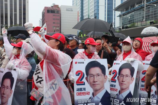 2일 부산역 광장에서 지지자들이 비옷을 입고 김문수 국민의힘 대선 후보를 향해 환호하고 있다. 양다경 기자