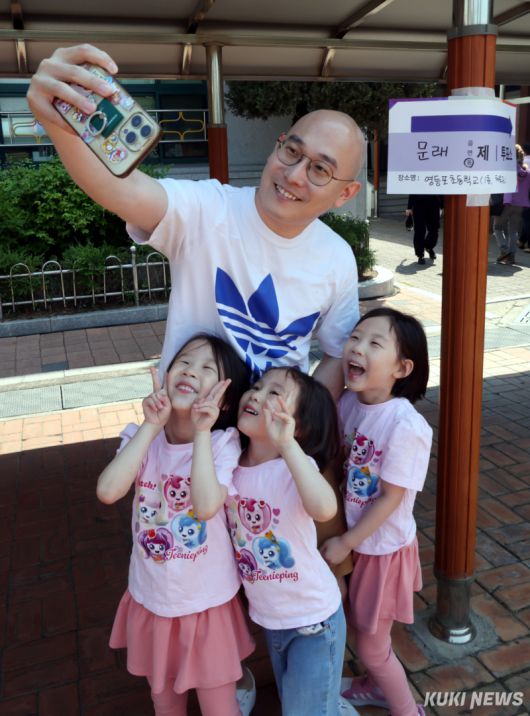 제21대 대통령 선거일인 3일 서울 영등포초등학교 내에 설치된 문래동 제1투표소에서 투표를 마치고 나온 한 가족이 밝은 표정으로 인증샷을 찍고 있다.