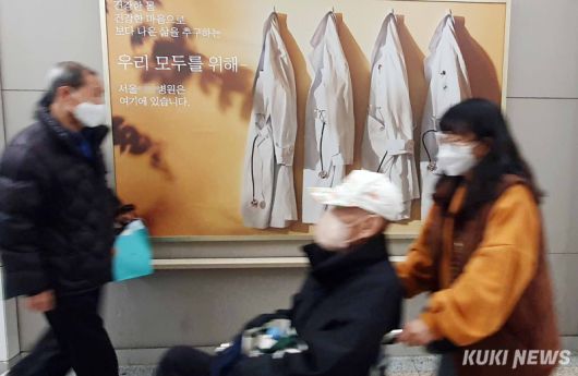 서울의 한 상급종합병원 로비에 걸린 병원 홍보물 앞으로 환자와 보호자가 지나가고 있다. 곽경근 대기자