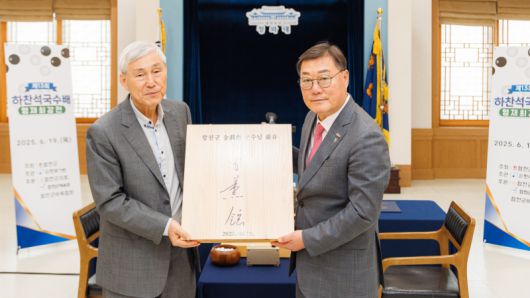 영화 ‘승부’ 실제 주인공 조훈현 9단(왼쪽)이 김윤철 합천군수에게 휘호반을 전달했다. 한국기원 제공