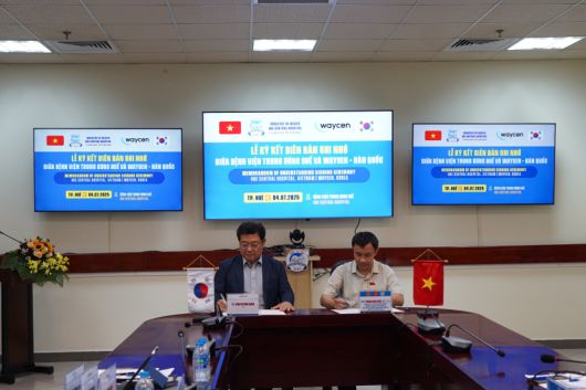 김경남 웨이센 대표(왼쪽)와 팜느히엡 베트남 후에중앙병원 병원장이 업무협약(MOU) 문서에 서명을 하고 있다. 웨이센 제공