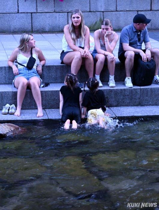 12일 불볕 더위가 연일 기승을 부리고 있는 가운데 청계천을 찾은 외국인 어린이들이 천에 몸을 담그고 더위를 식히고 있다.