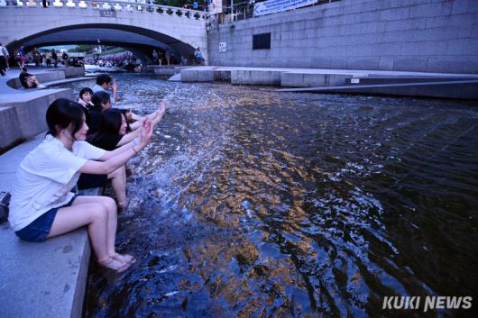 불볕 더위가 연일 기승을 부리고 있는 가운데 12일 청계천을 찾은 대학생들이 천에 발을 담그고 물장난을 치고 있다.