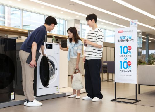 삼성전자 모델이 에너지 소비효율 1등급의 '세탁건조기'와 '에어컨' 제품의 설명을 듣고 있다. /삼성전자