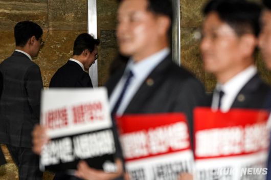 김민석 국무총리가 15일 서울 여의도 국회 본회의장 앞에서 송언석 국민의힘 원내대표의 ‘막말 논란’을 규탄하는 더불어민주당 의원들 옆으로 지나가고 있다.