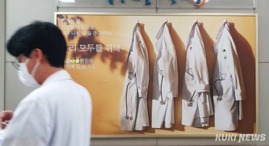 서울의 한 상급종합병원 로비에 걸린 병원 홍보물 옆으로 의료진이 이동하고 있다. 쿠키뉴스 자료진