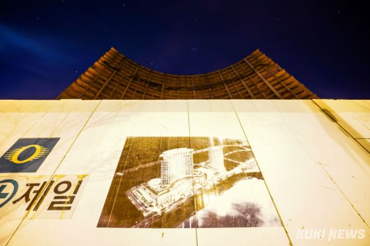 지난 18일 밤 인천 영종도 미단시티에 지어질 예정이었던 외국인 전용 카지노 리조트 조감도 너머로 공사가 중단된 채 남겨진 콘크리트 골조가 서 있다.