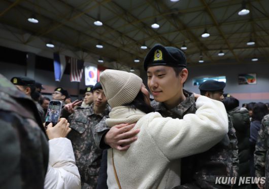 36사단 백호 신병교육대대 수료식에서 한 신병이 어머니를 껴안으며 환하게 웃고 있다.