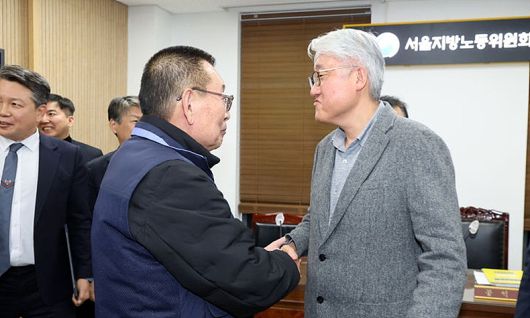 지난 14일, 서울 영등포구 서울지방노동위원회에서 열린 특별조정위원회 2차 사후 조정회의에서 교섭을 타결한 (사진 왼쪽)박점곤 전국자동차노동조합연맹 서울시버스노동조합 위원장과 김정환 서울시버스운송사업조합 이사장이 악수하고 있다. ⓒ뉴시스
