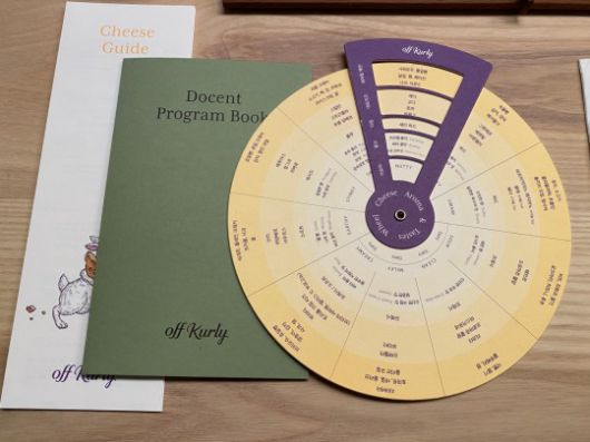 컬리가 만든 치즈 가이드와 도슨트 프로그램 북, 치즈 휠./ 사진 촬영 = 홍지인 기자