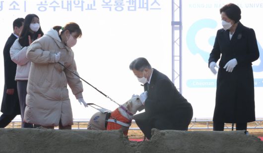 문재인 대통령이 29일 충남 공주시 공주대학교 옥룡캠퍼스에서 열린 공주대학교 부설 특수학교 설립 기공식에서 시삽을 마친 뒤 반가움을 표시하는 시각장애인 안내견 평화를 쓰다듬고 있다. 공주대학교 부설 특수학교는 장애인의 특기와 적성을 살리는 국내 첫 국립 직업 특성화 특수학교이다. 연합뉴스