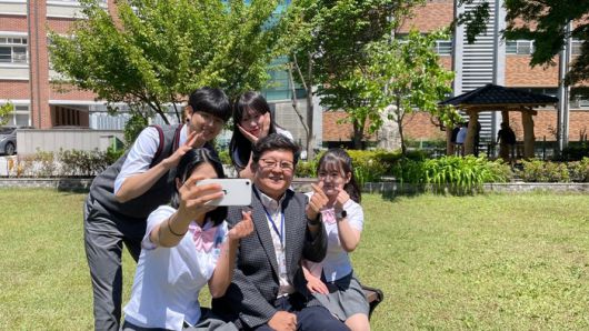 최경호 근명고 교장과 학생들이 교정에서 사진을 찍고 있다.