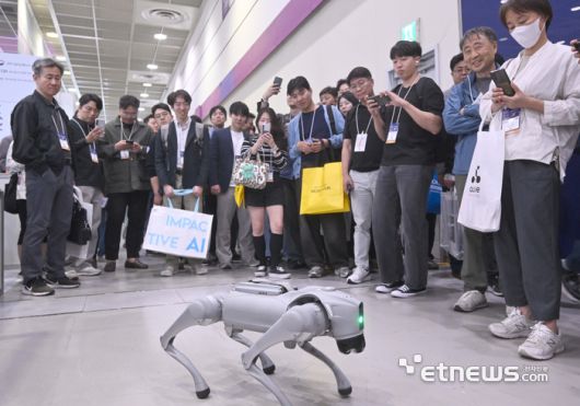 국내 최대 정보통신기술(ICT) 축제 '월드IT쇼(WIS) 2025 ICT융합제조지능화진흥연구센터에서 한양대가 프로그래밍한 4족 보행로봇을 관람객들이 보고 있다.  박지호기자 jihopress@etnews.com