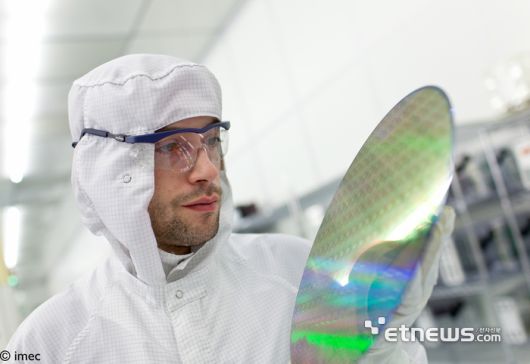 아이멕(imec) 클린룸에서 연구원이 웨이퍼를 들고 있다.