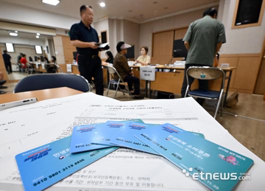 이재명 정부 첫 대규모 경기부양책인 민생회복 소비쿠폰(민생쿠폰) 신청 첫 날인 21일 서울 양천구 신정3동주민센터에서 시민들이 접수를 하고 있다. 민생쿠폰은 오는 9월 12일까지 온·오프라인을 통해 1차 신청을 받는다. 지원금액은 국민 1인당 기본 15만원이며 차상위 계층과 한부모가족은 1인당 30만원, 기초생활수급자는 1인당 40만원을 받는다.  이동근기자 foto@etnews.com