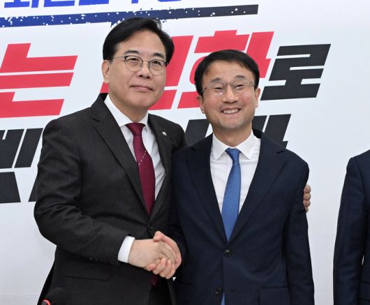 더불어민주당 한병도 신임 원내대표(오른쪽)가 12일 국회에서 취임 인사차 국민의힘 송언석 원내대표를 만나 손을 잡고 기념 촬영을 하고 있다. 연합뉴스