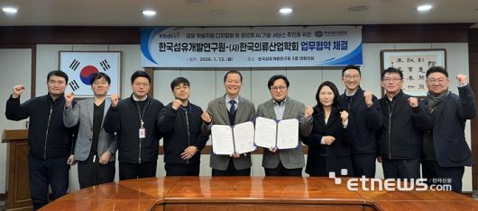 김성만 KTDI 원장(왼쪽에서 다섯번째)와 고준석 한국의류산업학회장 등 관계자들이 업무협약을 맺고 있다.