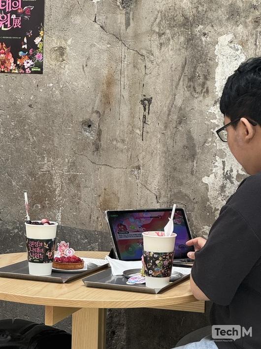 13일 서울 성수동 서브젝티브 카페에서 열린 '열정과 나태의 낙원전'을 찾은 사용자가 게임을 하며 시간을 보내고 있다. / 사진=서미희 기자