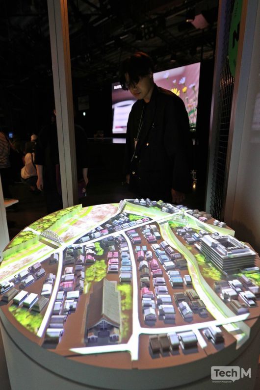 지난달 10일 일본 '2025 오사카·간사이 엑스포'에 마련된 네이버클라우드 전시관 내부에서 한 스태프가 도심지를 구현한 디지털트윈 코너 모형을 살펴보고 있다. /사진=임경호 기자