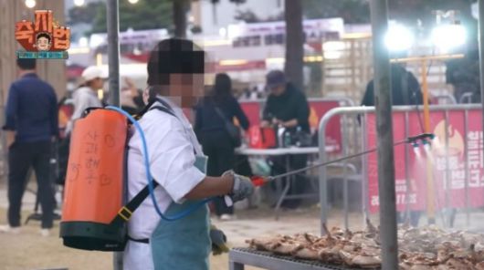 한 직원이 지역축제 현장에서 농약통에 든 사과주스를 음식에 뿌리고 있는 모습. [사진=백종원 유튜브 캡처]