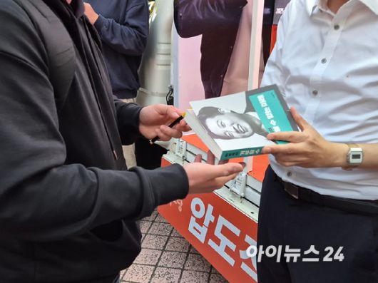 이준석 개혁신당 제21대 대통령선거 후보가 15일 오후 서울 지하철 2호선 건대입구역 인근 젊음의거리에서 유세하는 도중 한 지지자로부터 저서에 싸인을 요청받고 있다. [사진=김주훈 기자]