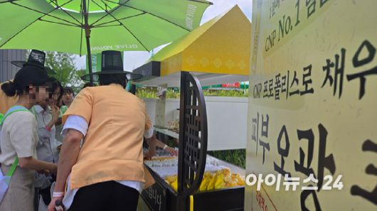 2025 올리브영 페스타에 마련된 한 부스에서 소비자가 이벤트를 참여해 상품을 받고 있다. [사진=진광찬 기자]