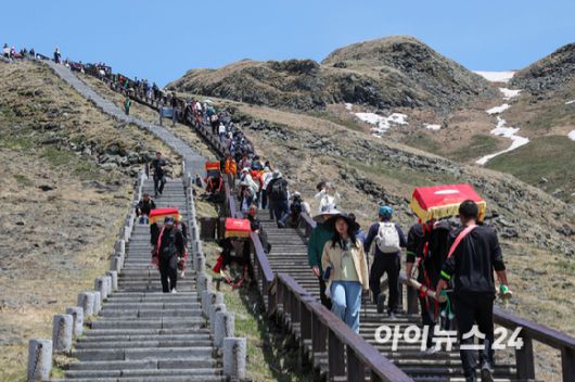 12일 백두산 서파를 통해 천지를 올라가는 1442개 계단길의 모습. 2인 1조의 가마꾼들이 승객을 싣고 나르는 모습을 쉽게 목격할 수 있다. 가격은 150~400위안 정도. [사진=정소희 기자]