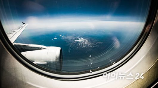 13일 오전 연길공항에서 인천공항으로 가는 비행기 탑승 중 창가에서 바라본 백두산의 모습. [사진=정소희 기자]