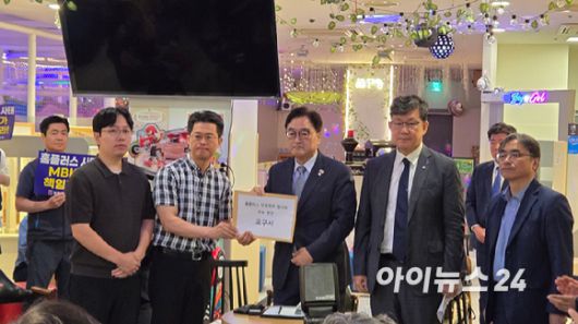 우원식 국회의장이 입점 점주 협의회와 간담회에서 현안요구서를 받아들고 있다. [사진=진광찬 기자]