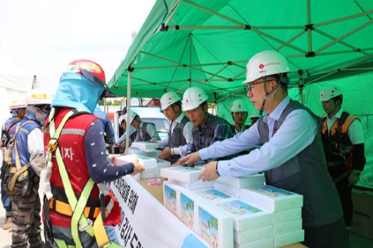 박현철 롯데건설 부회장(앞줄 오른쪽)이 대구 ‘타임빌라스 수성’ 현장에서 근로자들에게 아이스크림 츄러스와 이온음료, 혹서기 용품 등을 건네고있다. [사진=롯데건설]