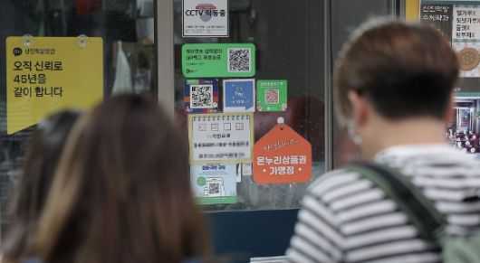 정부가 민생회복 소비쿠폰 1차 지급계획을 발표한 가운데, 전통시장 점포에 기존 골목경제 소비 활성화를 위한 온누리상품권 가맹 팻말이 붙어 있다. [사진=연합뉴스]