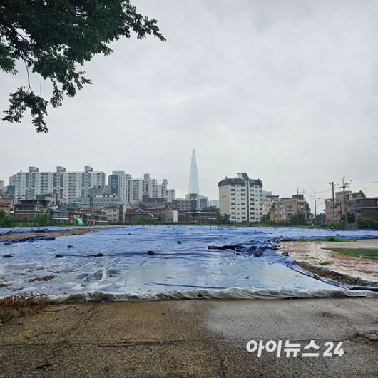 서울 송파구 풍납동의 '창의마을 풍납캠프' 부지에 가까이 가보니 시설물이 철거된 자리에 큰 천이 뒤덮인 채 방치돼 있다. 2025.07.16 [사진=이효정 기자 ]