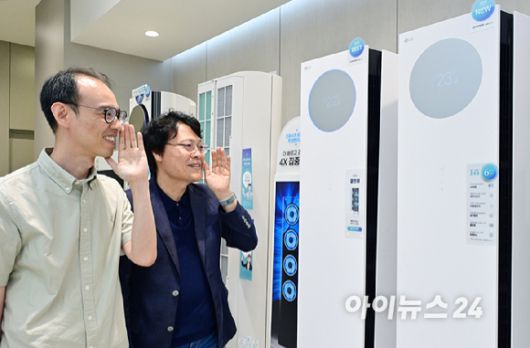 LG전자 박재성 책임(왼쪽)과 김락용 연구위원이 22일 서울 영등포구 더현대에 자리한 LG전자 매장에서 에어컨 신제품의 AI 음성인식 기능을 선보이고 있다. [사진=LG전자]