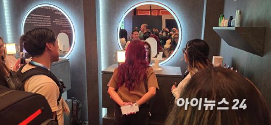 4일(현지시간) 미국 라스베이거스 윈 호텔에서 열린 ‘삼성 퍼스트 룩’ 전시관에서 ‘AI 미러’로 피부를 측정하는 관람객. [사진=박지은 기자]
