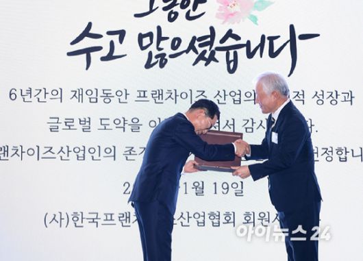 나명석 신임 한국프랜차이즈산업협회장(왼쪽, 웰빙푸드 회장)이 19일 오후 서울 여의도 콘래드 서울 그랜드볼룸에서 열린 한국프랜차이즈산업협회 협회장 이·취임식 및 비전 선포식에서 정현식 전 한국프랜차이즈산업협회장(가자주류 대표)에게 감사패를 수여하고 있다. [사진=정소희 기자]