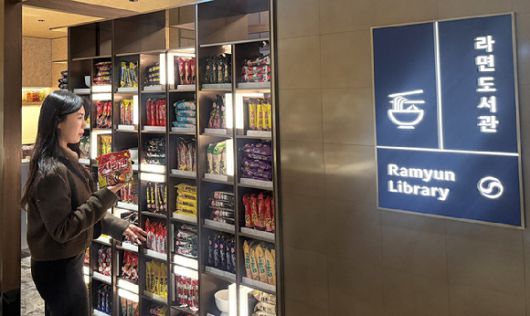 한 방문객이 다양한 라면이 진열된 '라면도서관'을 구경하고 있다. [사진=오뚜기]