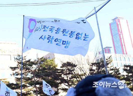 윤석열 대통령 탄핵소추안 표결을 앞둔 14일 오후 서울 여의도 국회 앞에서 열린 윤 대통령 탄핵을 촉구하는 집회에 '전국 응원봉 없는 사람 연맹' 깃발이 보이고 있다. [사진=정소희 기자]